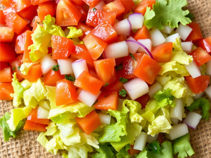 Visual of chopped lettuce, tomato, and onion.